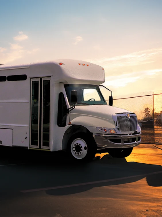White shuttle bus parked next to a security fence at a prison near NYC